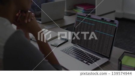 Showing silver laptop running terminal in office, man wearing light top, sticky notes, copy space Showing silver laptop running terminal in office, man wearing light top, sticky notes, copy space 139574944