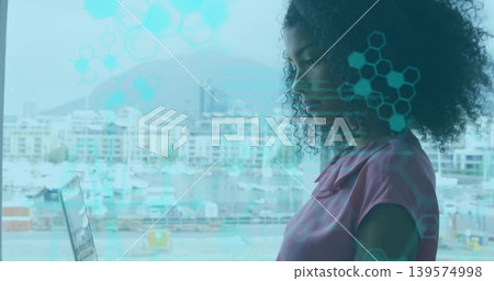 Standing woman wearing pink blouse looking at open laptop in marina office, HUD overlay, copy space Standing woman wearing pink blouse looking at open laptop in marina office, HUD overlay, copy space 139574998