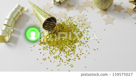Scattering gold confetti from tipped cone hat on white tabletop with green avatar and star confetti 139575027