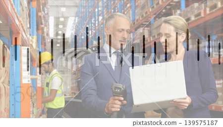 Reviewing stock managers suit or blazer using laptop scanner in warehouse, hi-vis-vest yellow-hardha 139575187