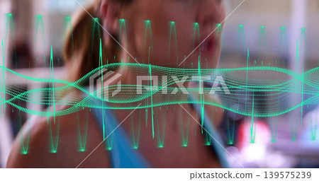 Showing mid-adult woman wearing blue sports top exercising in studio, with teal waveform overlay Showing mid-adult woman wearing blue sports top exercising in studio, with teal waveform overlay 139575239