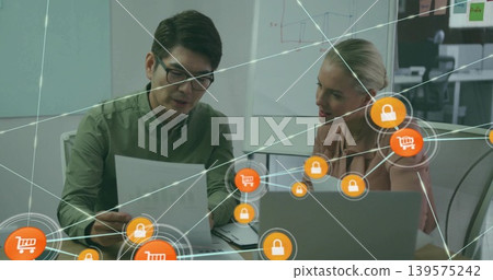 Examining document at office, man in green top explaining, woman in light top viewing laptop, icons 139575242