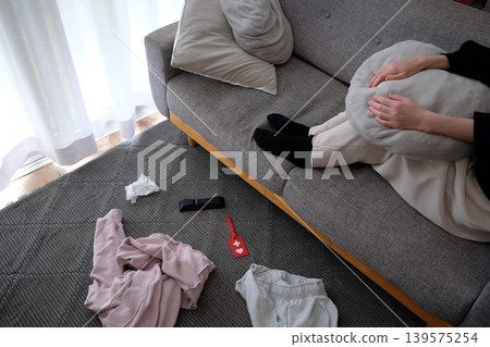A woman troubled by her cluttered living room 139575254