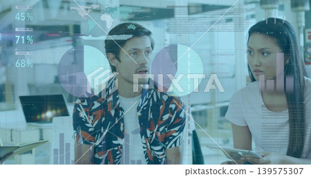 Coworkers discussing in office, man in printed shirt, woman in light tee holding tablet with charts Coworkers discussing in office, man in printed shirt, woman in light tee holding tablet with charts 139575307
