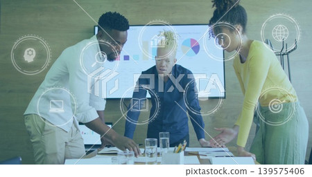Leaning three person team reviewing charts at table in office wear, with monitor, reports, overlays Leaning three person team reviewing charts at table in office wear, with monitor, reports, overlays 139575406