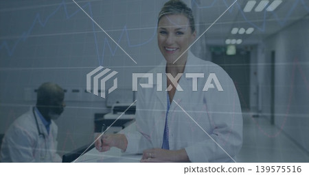 Writing woman in white lab coat completing paperwork at nurse station, with pen and stethoscope Writing woman in white lab coat completing paperwork at nurse station, with pen and stethoscope 139575516