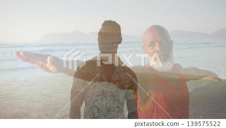 Standing paired men extending arms on beach, wearing sunglasses, patterned shirt and red tank Standing paired men extending arms on beach, wearing sunglasses, patterned shirt and red tank 139575522