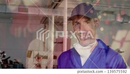 Smiling mechanic in blue jumpsuit and cap working in garage, with mask, motorcycle, copy space Smiling mechanic in blue jumpsuit and cap working in garage, with mask, motorcycle, copy space 139575592