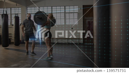 Lifting trainee in sports bra shorts holding loaded barbell at gym masked trainer spotting AR grid Lifting trainee in sports bra shorts holding loaded barbell at gym masked trainer spotting AR grid 139575731