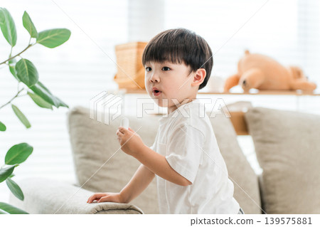 A boy eating snacks in the living room. A boy eating snacks in the living room. 139575881