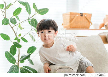 A boy eating snacks in the living room. 139575882