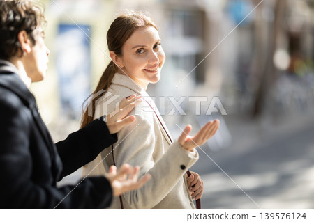 Man flirts with young woman on the street of spring city Man flirts with young woman on the street of spring city 139576124