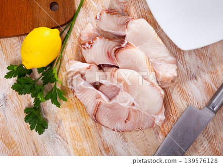 Uncooked tiger shark fillet fish with parsley and lemon on table Uncooked tiger shark fillet fish with parsley and lemon on table 139576128