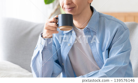 A man relaxing and drinking coffee A man relaxing and drinking coffee 139576146