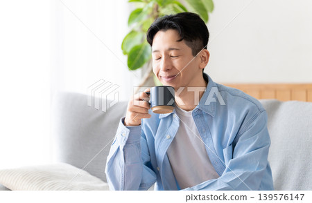 A man relaxing and drinking coffee A man relaxing and drinking coffee 139576147