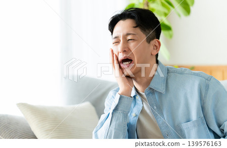 一名男子正遭受牙痛的折磨 一名男子正遭受牙痛的折磨 139576163