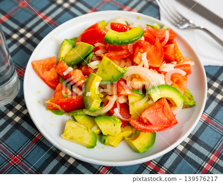 Fresh avocado, tomato, onion salad in white plate Fresh avocado, tomato, onion salad in white plate 139576217