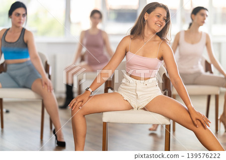 Sitting on chair, girl train to perform lap dance, interacting with imaginary partner 139576222