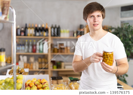 Young man choosing olives at grocery store 139576375