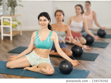 Group of young women doing yoga using exercise balls Group of young women doing yoga using exercise balls 139576392