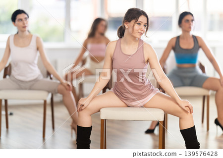 Sitting on chair, girl train to perform lap dance, interacting with imaginary partner 139576428