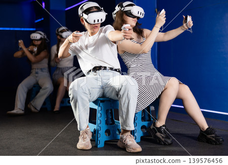 Girl in headset playing VR games against each other in room Girl in headset playing VR games against each other in room 139576456