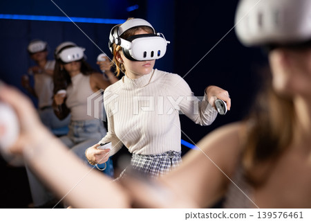 Excited young girl playing virtual reality game Excited young girl playing virtual reality game 139576461