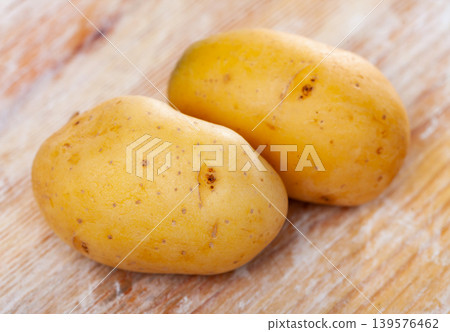 Closeup of two organic fresh potatoes on wooden background 139576462