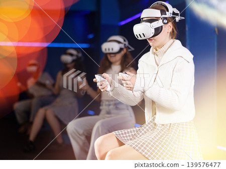Excited young girl playing virtual reality game Excited young girl playing virtual reality game 139576477