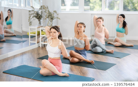 Group of women of working out practice Lord of fishes pose Group of women of working out practice Lord of fishes pose 139576484