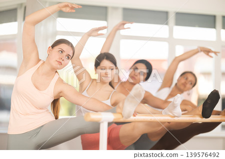 Ballet pose grand batman - young ballerinas at choreography lesson 139576492