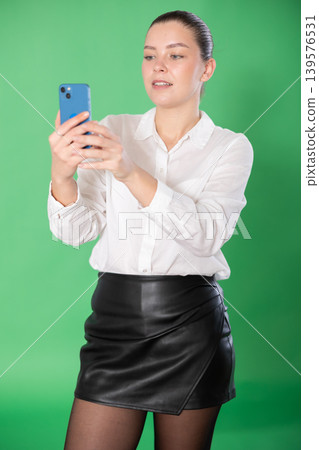 woman uses qr code for online payment on a green background woman uses qr code for online payment on a green background 139576531