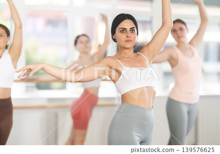 Close-up view of young girl practicing ballet positions standing in row 139576625