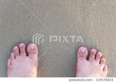 Bare feet standing on wet sandy beach with natural texture and relaxed vacation atmosphere during seaside travel and outdoor leisure time Bare feet standing on wet sandy beach with natural texture and relaxed vacation atmosphere during seaside travel and outdoor leisure time 139576833