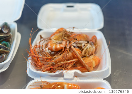 Grilled river prawns served in takeaway food box with fresh seafood texture and savory street food style ready for eating Grilled river prawns served in takeaway food box with fresh seafood texture and savory street food style ready for eating 139576846