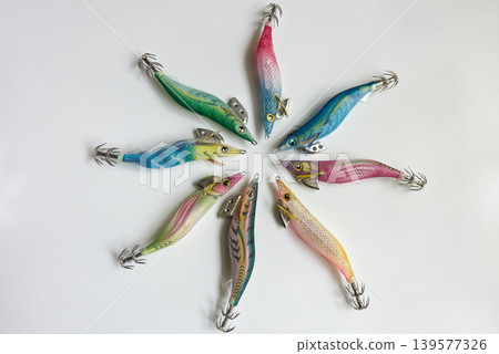 一圈色彩鮮豔的魷魚鉤在白色背景上排列。 一圈色彩鮮豔的魷魚鉤在白色背景上排列。 139577326