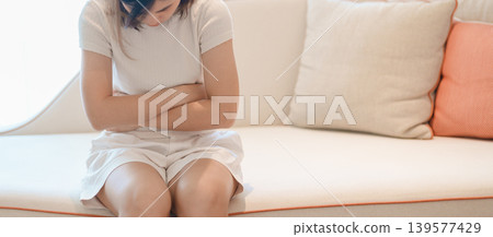 woman having abdomen ache due to Stomach pain, digestion with constipation or Diarrhea from food poisoning, female problem and Endometriosis, Hysterectomy, Stomachache and Menstrual on sofa at home woman having abdomen ache due to Stomach pain, digestion with constipation or Diarrhea from food poisoning, female problem and Endometriosis, Hysterectomy, Stomachache and Menstrual on sofa at home 139577429