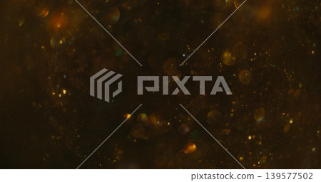 Confetti texture blur. Color bokeh blink. Golden shimmering snow stream on dark abstract background. Night circles reflection mix. Confetti texture blur. Color bokeh blink. Golden shimmering snow stream on dark abstract background. Night circles reflection mix. 139577502