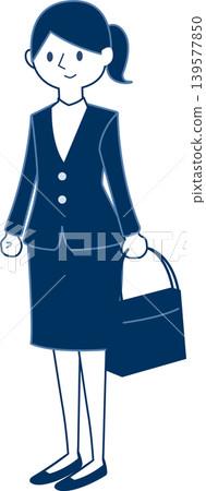 A smiling woman in a work suit stands with a bag in her hand. A smiling woman in a work suit stands with a bag in her hand. 139577850