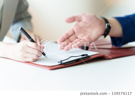 Hand of a woman signing a contract Hand of a woman signing a contract 139578117