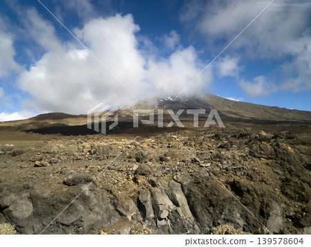 Volcanic mountain landscape with clouds and rocky terrain Volcanic mountain landscape with clouds and rocky terrain 139578604