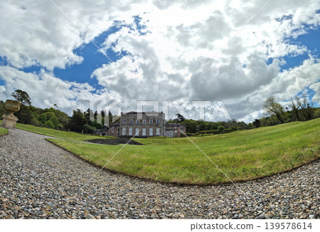 Historic country mansion with landscaped gardens and dramatic sky Historic country mansion with landscaped gardens and dramatic sky 139578614