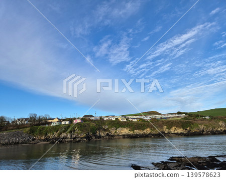 Coastal village houses beneath a wide blue sky Coastal village houses beneath a wide blue sky 139578623