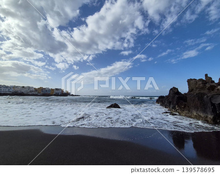 Waves Rolling Onto a Rocky Black Sand Beach 139578695