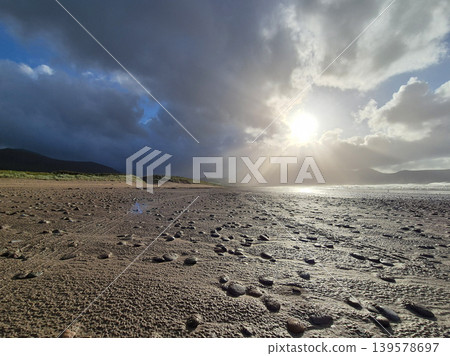 Stormy beach with dramatic sunlight and wet sand Stormy beach with dramatic sunlight and wet sand 139578697