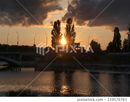 Sunset Over River With Bridge and Silhouetted Trees Sunset Over River With Bridge and Silhouetted Trees 139578763