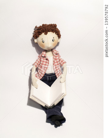 Handmade boy doll reading an open book Handmade boy doll reading an open book 139578792