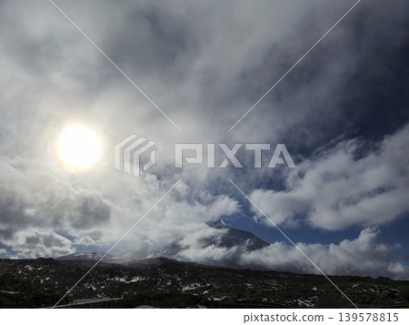 Sunlight Breaking Through Clouds Over Mountain Landscape 139578815