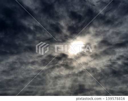 Bright sun behind dramatic dark clouds Bright sun behind dramatic dark clouds 139578816