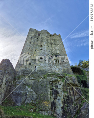Ancient stone tower on rocky hillside 139578818